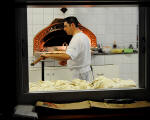 9. Mentre le pagnotte lievitano avvolte in caratteristici panni, sta preparando e infornando pizze per tutti i gusti.